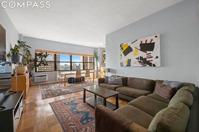 living room with an AC wall unit and light wood-type flooring