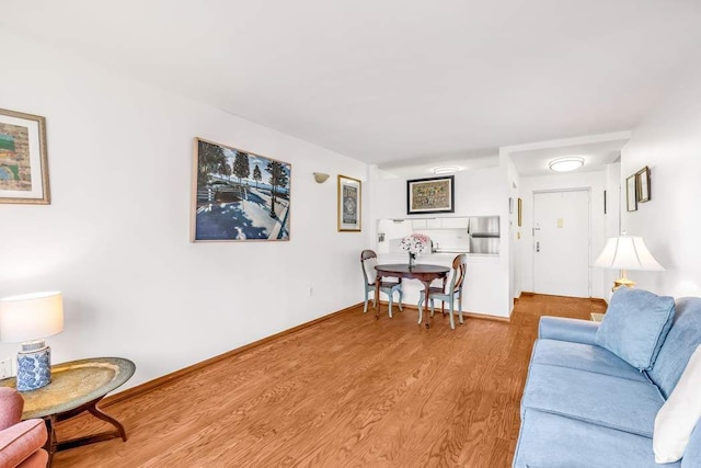 living area featuring baseboards and wood finished floors