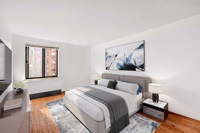 bedroom featuring baseboards and wood finished floors