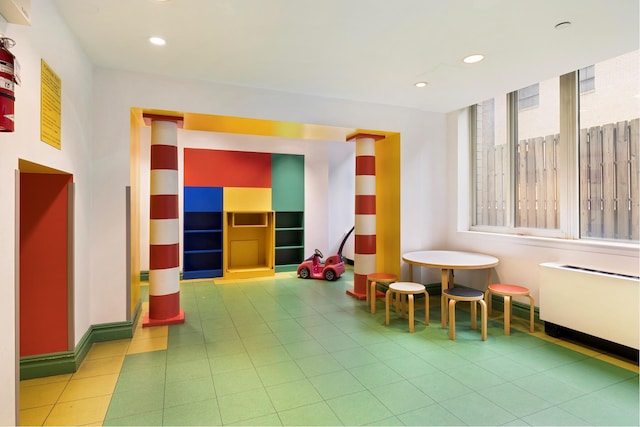 rec room with tile patterned flooring, radiator, recessed lighting, and baseboards