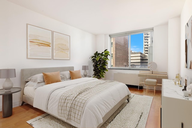 bedroom featuring light wood finished floors and radiator