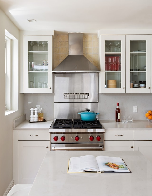 104-106 Bedford St Unit 6Ab5A, New York City, NY 10014 - kitchen with stainless steel range, wall chimney range hood, backsplash, and light countertops