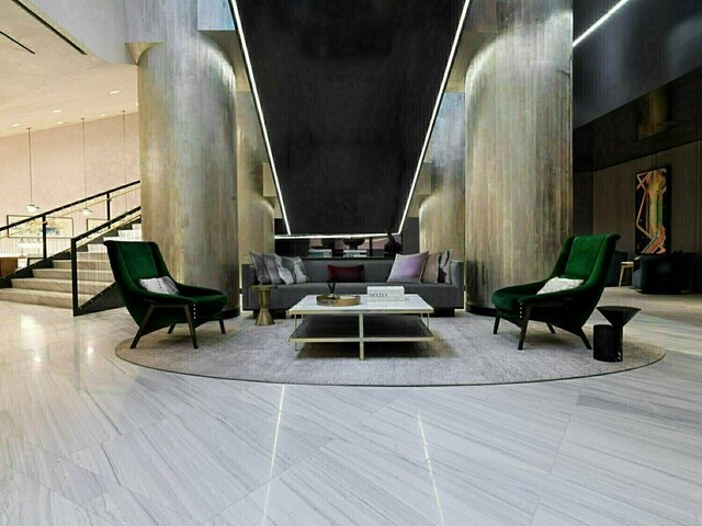 252 S St Unit 76E, New York City, NY 10002 - building lobby featuring a high ceiling, stairway, and wooden walls