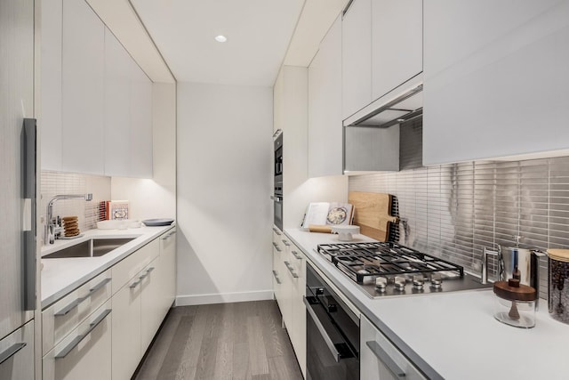252 S St Unit 76E, New York City, NY 10002 - kitchen with stainless steel appliances, a sink, baseboards, dark wood-type flooring, and modern cabinets