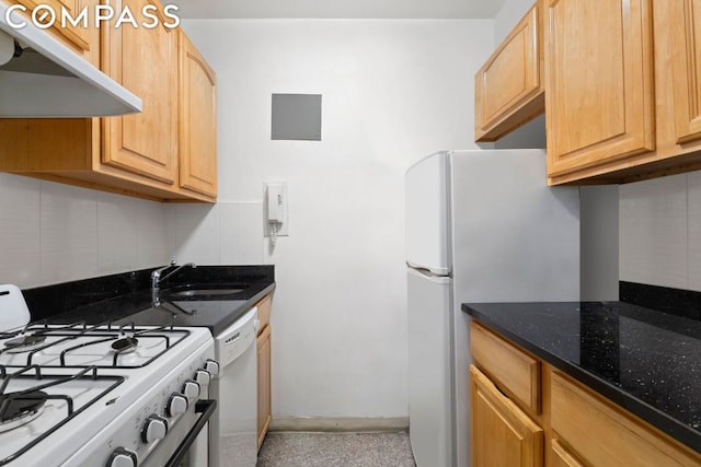 kitchen featuring sink, white appliances, dark stone countertops, range hood, and light brown cabinets