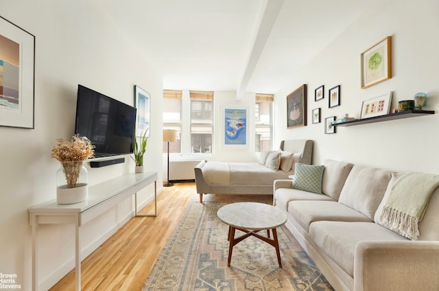 living room with light hardwood / wood-style flooring and beam ceiling