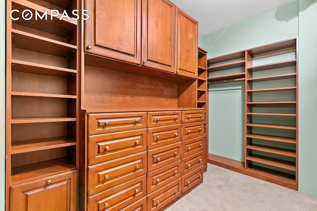 walk in closet featuring light carpet