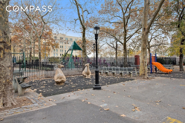 view of home's community featuring fence and playground community