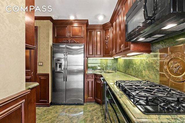 kitchen featuring dark brown cabinets, light countertops, decorative backsplash, black appliances, and a sink