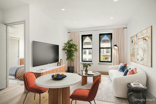 living room featuring a wall unit AC and light hardwood / wood-style flooring