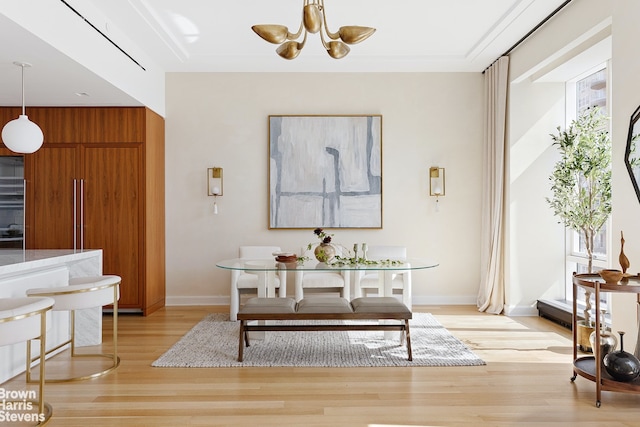 dining space with an inviting chandelier and light hardwood / wood-style flooring