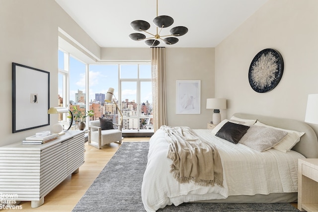 bedroom with light hardwood / wood-style flooring and a notable chandelier