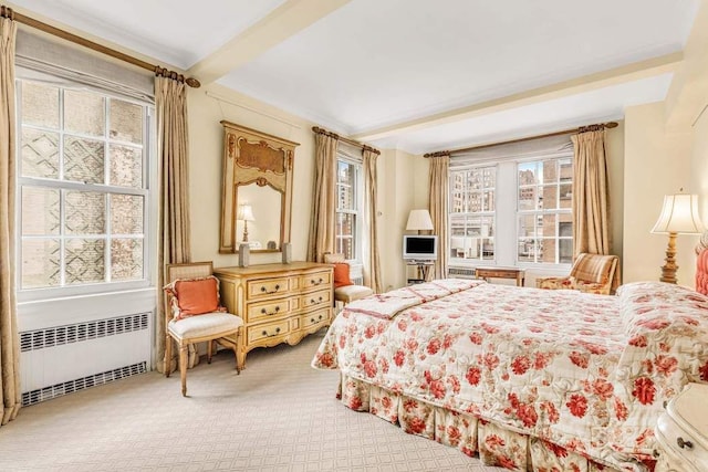 bedroom featuring carpet, radiator, and beamed ceiling