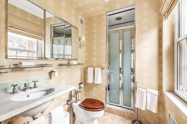 bathroom featuring toilet, tile patterned flooring, a shower with door, and sink