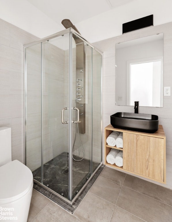 bathroom with toilet, a shower with shower door, and vanity