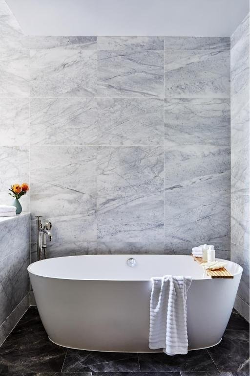 bathroom with a bath and tile walls