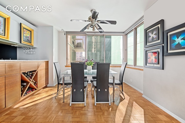 dining area with a ceiling fan and baseboards