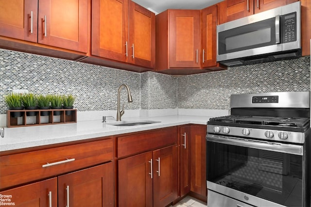 kitchen featuring decorative backsplash, appliances with stainless steel finishes, light stone counters, and a sink