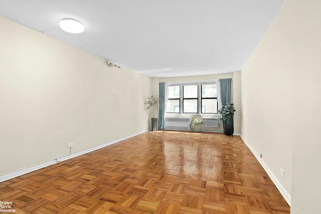 unfurnished room with radiator and baseboards