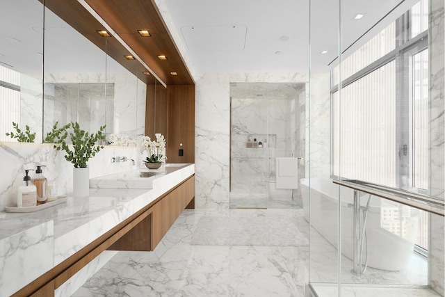 bathroom with marble tiled flooring, a marble finish shower, double vanity, and a freestanding tub