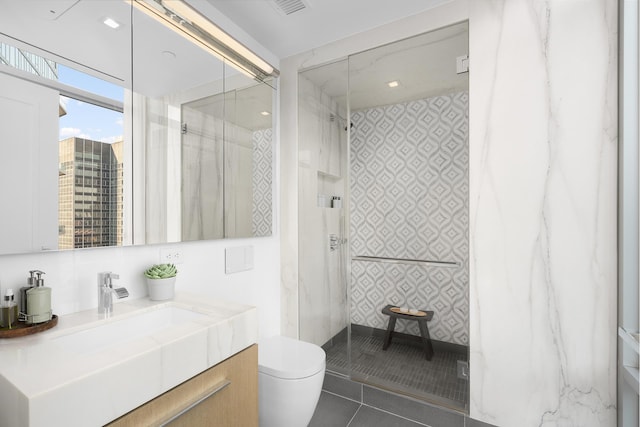 bathroom featuring wallpapered walls, a marble finish shower, toilet, vanity, and tile patterned flooring