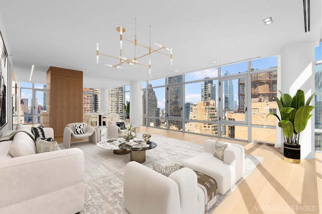 living room with light hardwood / wood-style floors, an inviting chandelier, and floor to ceiling windows