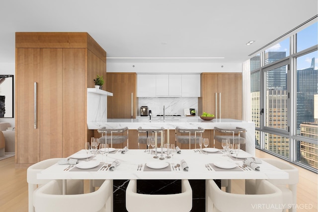 dining area with light wood-type flooring and a wall of windows