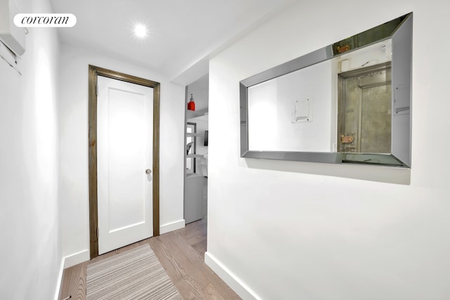 hallway with light wood-style flooring and baseboards