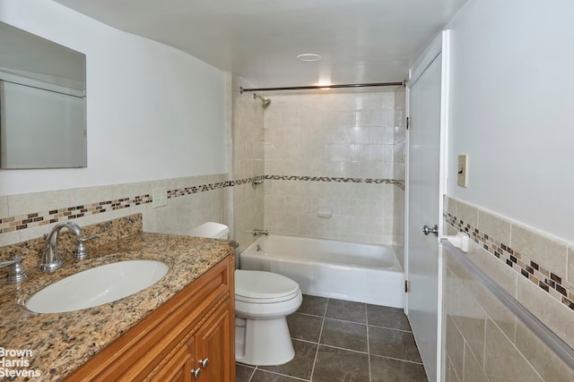 full bathroom featuring tile patterned flooring, tile walls, vanity, toilet, and tiled shower / bath