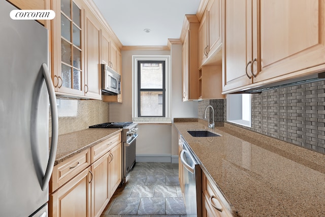 kitchen with a sink, stainless steel appliances, ornamental molding, and light brown cabinetry