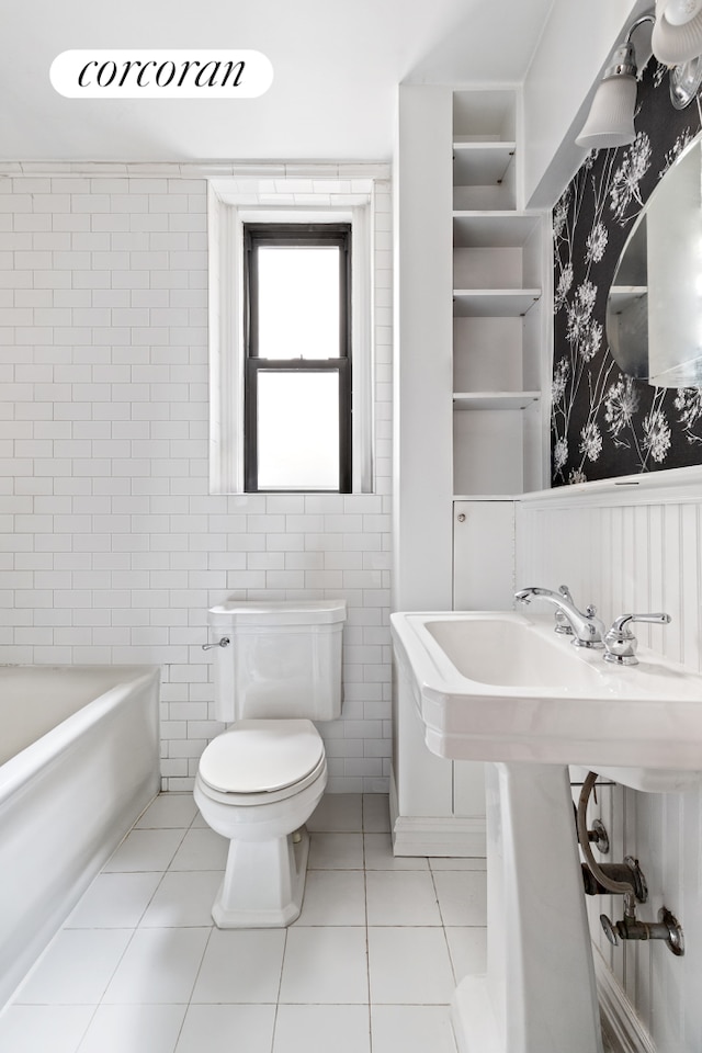 144 E 36th St Unit 1C, New York City, NY 10016 - full bathroom with wallpapered walls, tile patterned flooring, toilet, a bathtub, and wainscoting