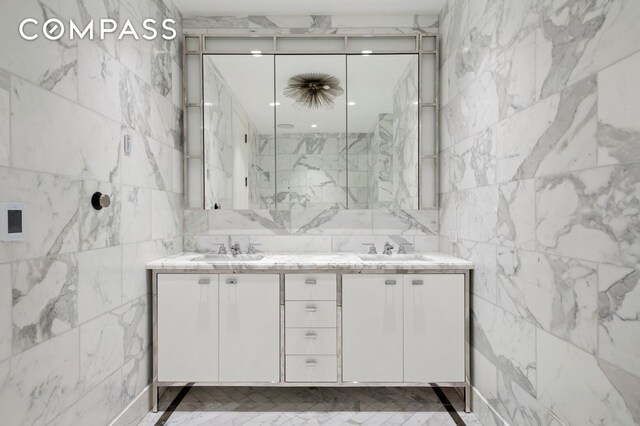 bathroom with vanity, tile walls, and a shower with door