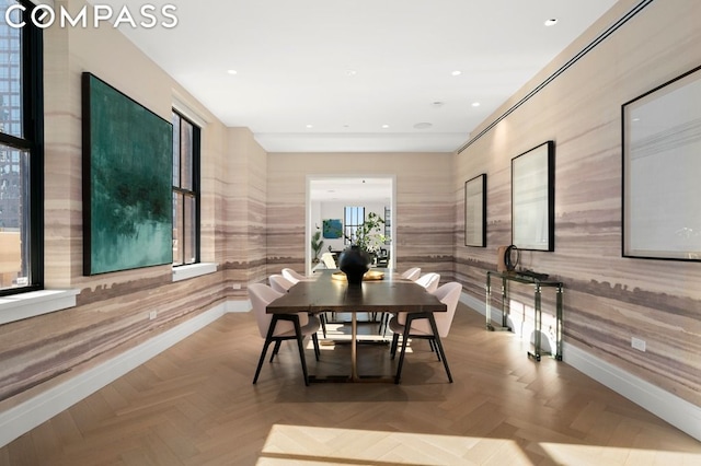 dining room featuring light parquet floors and wooden walls