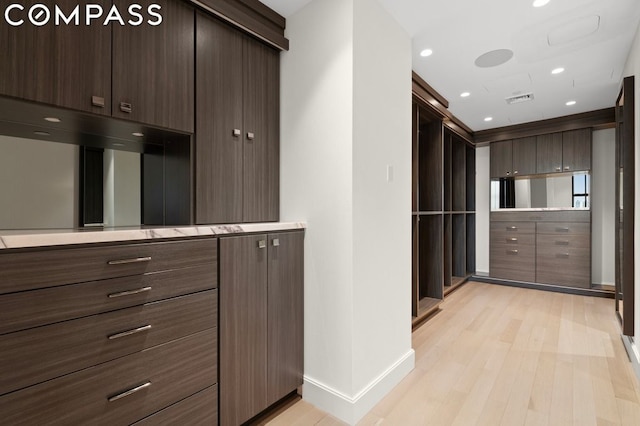 kitchen featuring dark brown cabinetry and light hardwood / wood-style flooring