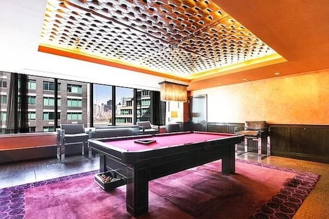 rec room with a raised ceiling and pool table