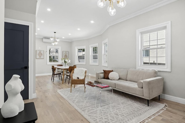 living room with an inviting chandelier, ornamental molding, a healthy amount of sunlight, and light hardwood / wood-style flooring