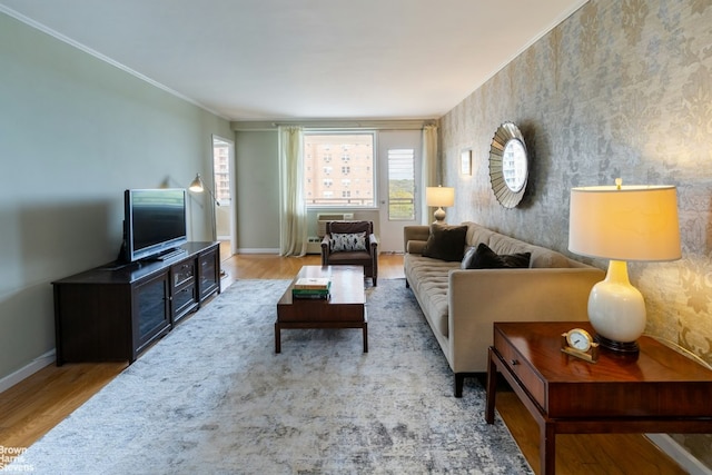 living area with ornamental molding, baseboards, and wood finished floors