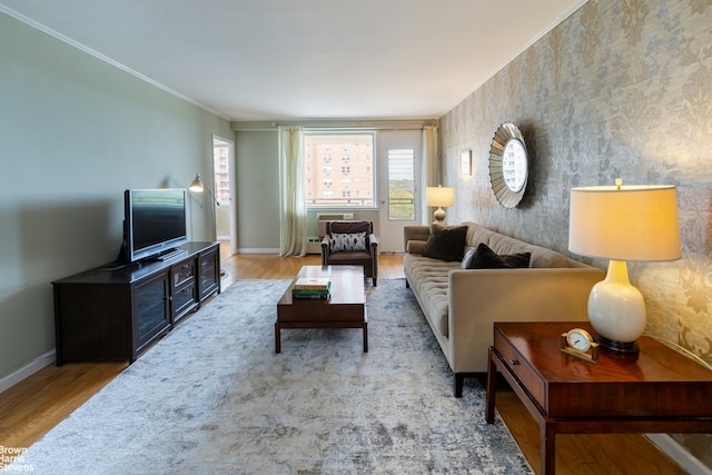 living room with crown molding, baseboards, and wood finished floors