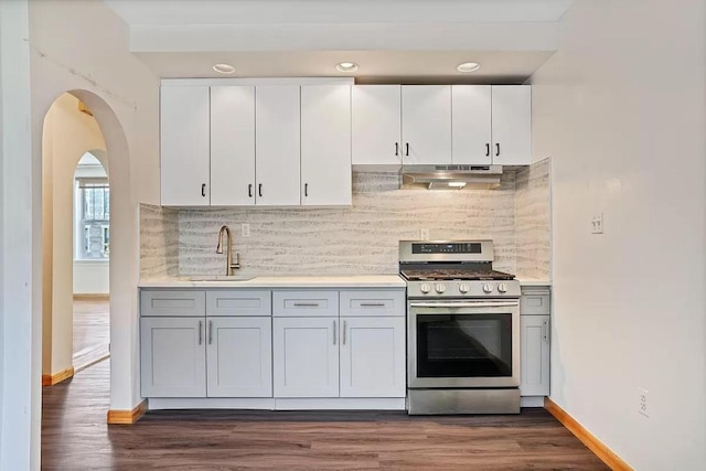 kitchen with sink, white cabinetry, stainless steel gas range oven, dark hardwood / wood-style flooring, and decorative backsplash