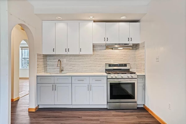 kitchen featuring gas range, light countertops, under cabinet range hood, white cabinetry, and a sink