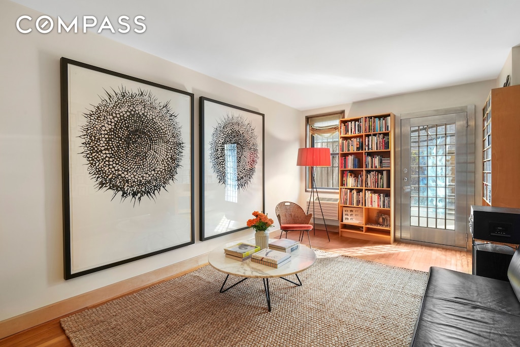 sitting room with baseboards and wood finished floors