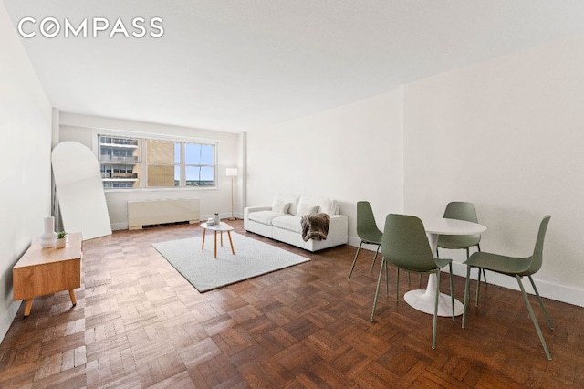 living room featuring parquet floors and radiator heating unit