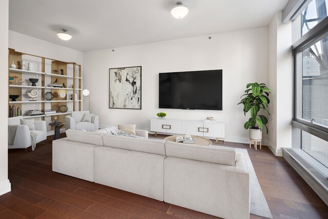 living area featuring dark wood-style flooring and baseboards