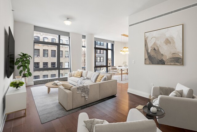 living room featuring a chandelier, expansive windows, baseboards, and hardwood / wood-style floors