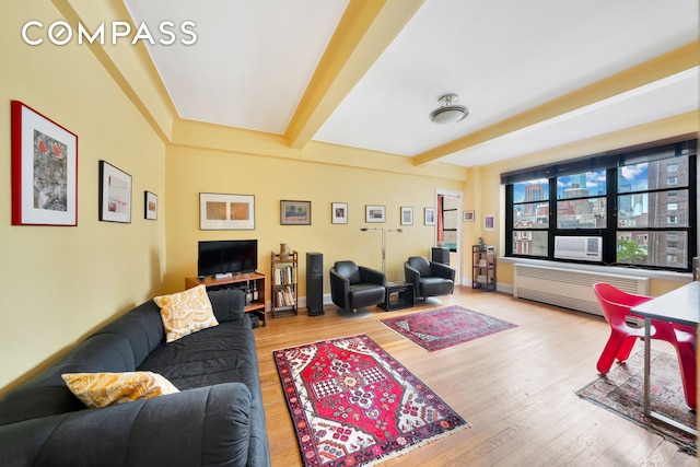 living room with beamed ceiling, baseboards, wood finished floors, and radiator heating unit