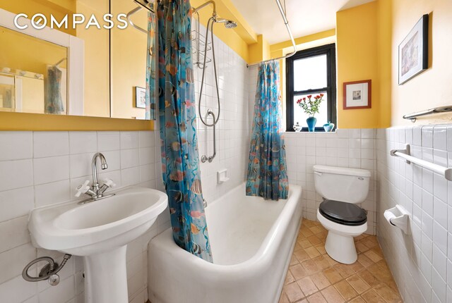 full bathroom with tile patterned flooring, toilet, wainscoting, tile walls, and shower / bathtub combination with curtain