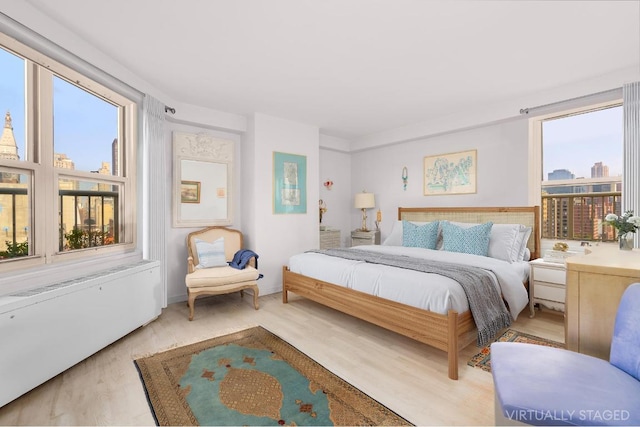 bedroom featuring multiple windows and light hardwood / wood-style flooring