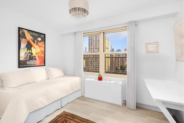 bedroom with light hardwood / wood-style floors and a chandelier