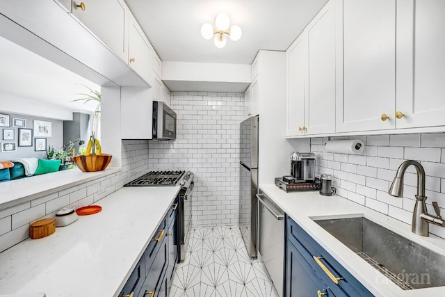 kitchen with appliances with stainless steel finishes, white cabinets, and sink