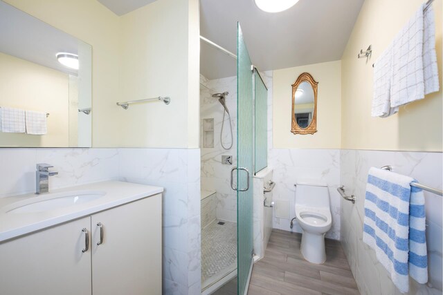 bathroom featuring toilet, tile walls, an enclosed shower, and vanity